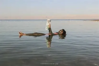 Floating in the Dead Sea with mud Jordan