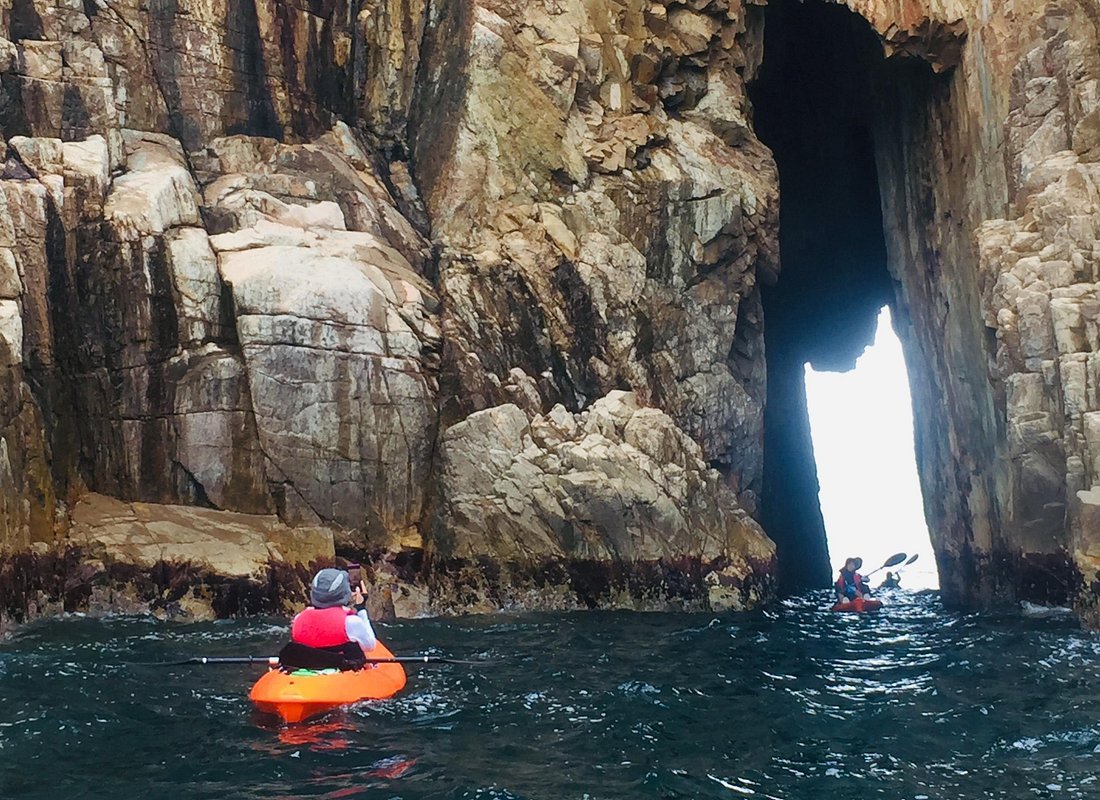 Sea kayaking Sai Kung Archipelago Hong Kong sea arch volcanic rock